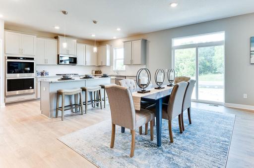 Centered within the main level, the home's dining space spans nearly 17-feet wide and rests just adjacent to the easy access onto your future deck! Photo of model home, color and options will vary.