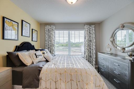 Each of the home's secondary bedrooms on the upper level come nicely sized and all feature their own private walk-in closet. Photo of model home, color and options will vary.