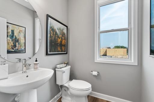 A private powder room is conveniently nestled between the main level flex room and great room. (*Photo of decorated model, actual homes colors and finishes will vary)