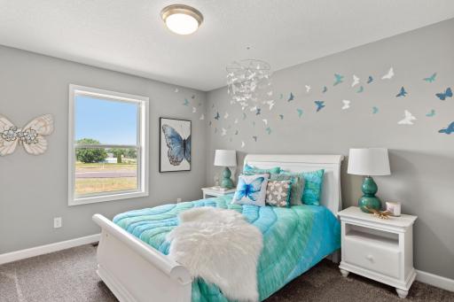 One of three generously sized secondary bedrooms with a spacious closet! (*Photo of decorated model, actual homes colors and finishes will vary)