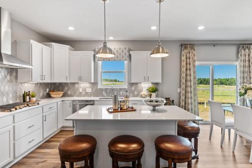 Enjoy plenty of seating at the kitchen island and dining area adjacent to the kitchen. Perfect for entertaining or having a family meal together. (*Photo of decorated model, actual homes colors and finishes vary)