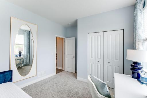 Main floor bedroom with closet is great for a work from home office or a guest space. *photo of model home
