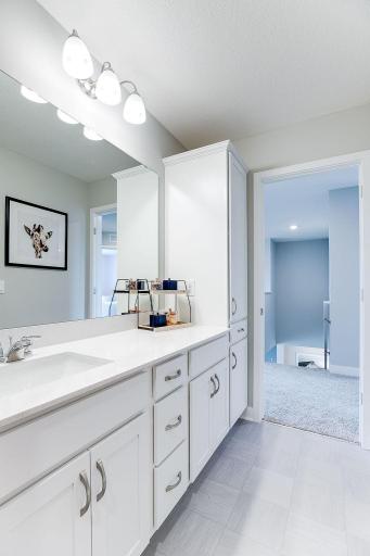 The upstairs spare bath includes plenty of cabinet storage - including a tall linen cabinet. Door between the sinks and the toilet and shower room! *photo of model home