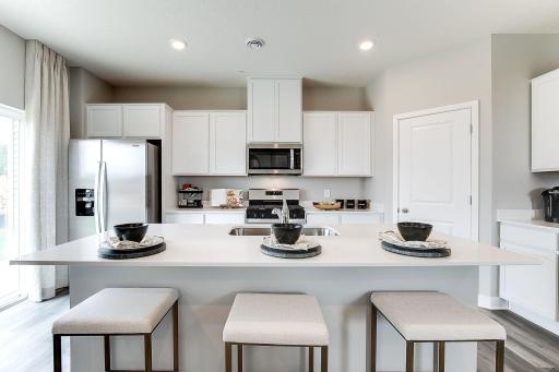A large quartz topped island anchors the kitchen. Photo of model, colors and finishes may vary.