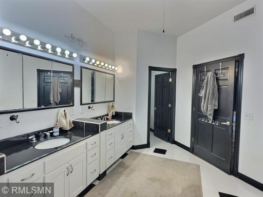 Imagine a glorious ensuite bathroom with tile flooring, double vanity and private stool area with a door.