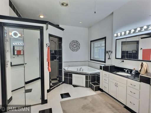 The primary bathroom is finished with a whirlpool tub, tile surrounds, walk-in closet and tons of cabinets.