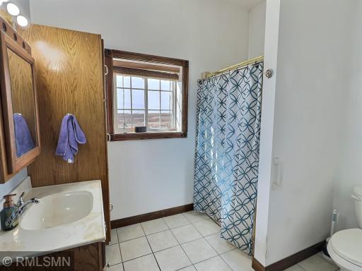 A spacious 3-quarter bathroom with tile flooring and nice cabinet space finishes off the mother-in-law suite.