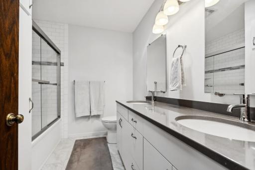 Outstanding full bath completely renovated features double sink, solid surface counter and subway tile