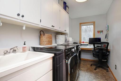 Main floor laundry is located off the garage and has ample cabinet and storage space. Additional nook for working from home or place to store important papers.