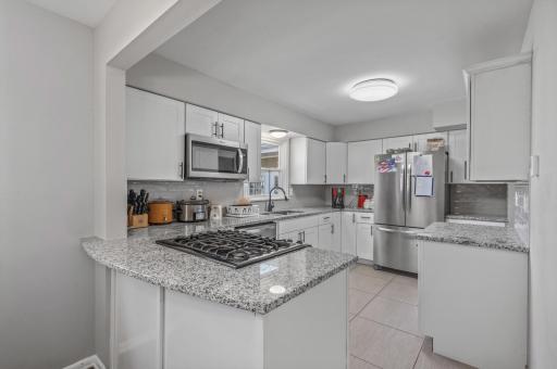 Completely renovated kitchen features granite counter tops and HEATED TILE FLOORS!