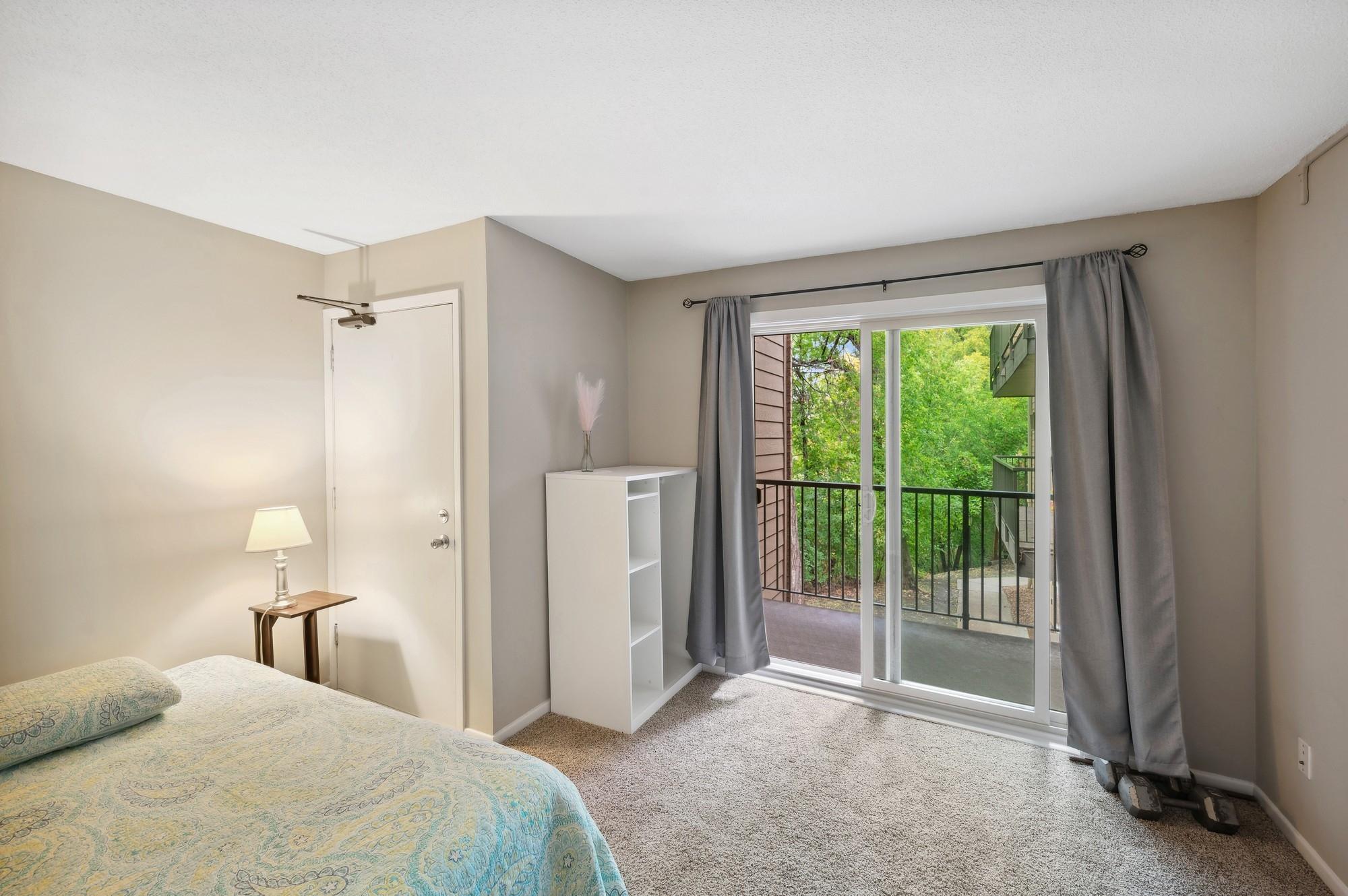 Secondary bedroom with balcony facing the woods/wetlands makes a great guest room or office.