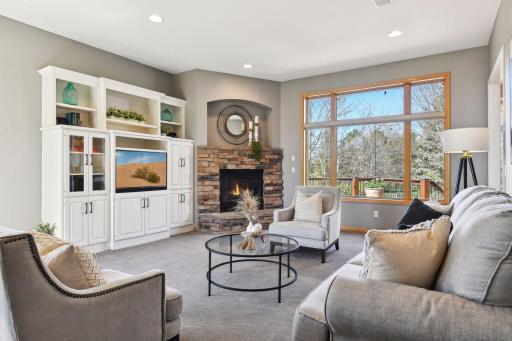 Entertain in the living room with built-in cabinetry flanking a stone fireplace.