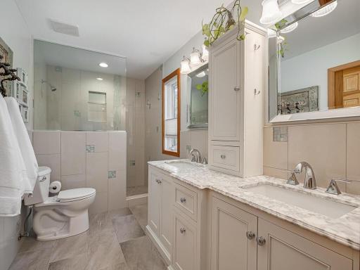 Primary bedroom en suite private bath offers a step-in shower, double marble vanity, and walk-in closet.