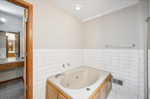 Upper level walk-through full bathroom, remodeled in 2020, with dual vanity, jet tub and separate walk-in shower