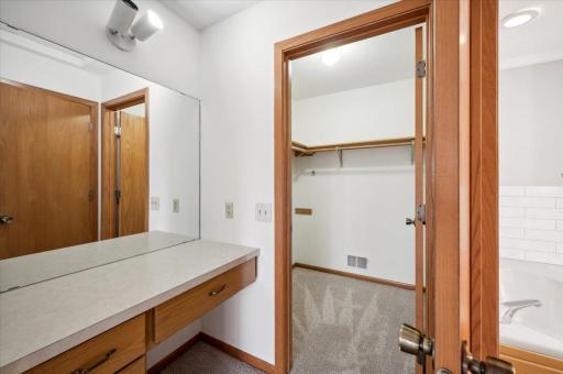 Primary bedroom suite with vanity area, walk-in closet, and access to the walk-through full bath