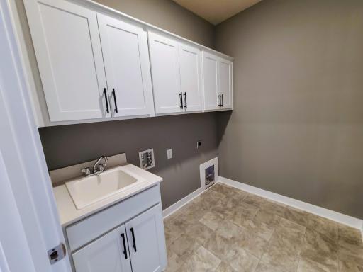 View of Laundry Room with sink base cabinet and wall cabinets. Photo of actual home.