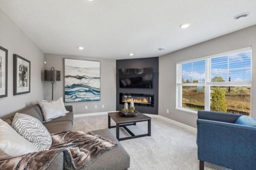 Photo for 21942 Primrose Path, Farmington, MN 55024 - Listing #6486300 Family room features a modern, corner electric fireplace plus wired above for flat-screen TV placement. (Photo of decorated model, actual home's finishes may vary slightly)