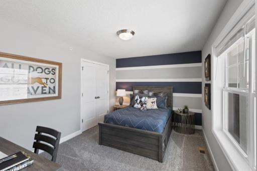Bedroom #2 on the upper level with large windows and large closet. (Photo of decorated model, actual home's finishes may vary slightly)