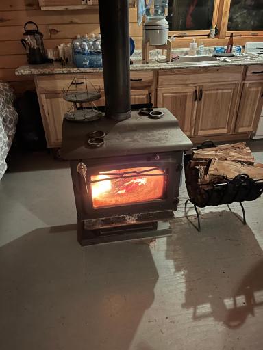Cabin Interior 6 wood stove showing sink_crock w water jug_cabinet handles.jpeg