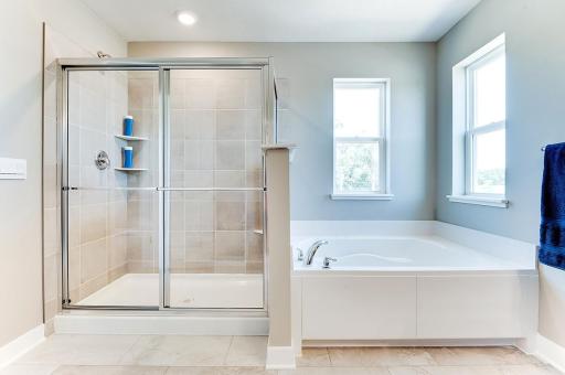 The primary bathroom has both a shower and a separate tub as well as double sinks in the vanity. *Photos of previous model home. Some colors and selections may vary.
