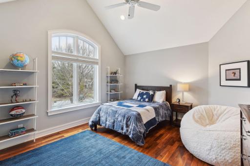 Upper Bedroom #2 with a spacious vaulted ceiling, views to the front of the home (north) and a walk-in closet.
