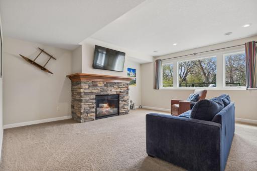 Sunlit lower level brick fireplace family room
