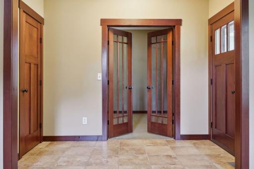 High-end entryway featuring solid wood doors, elegant tile flooring, and French doors leading to the home office.