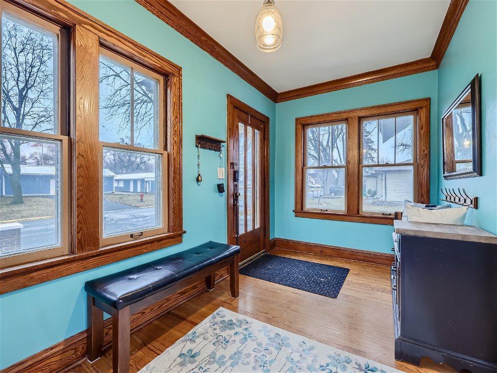 Bright and welcoming front entry porch/sunroom w/ beautiful wood floors.