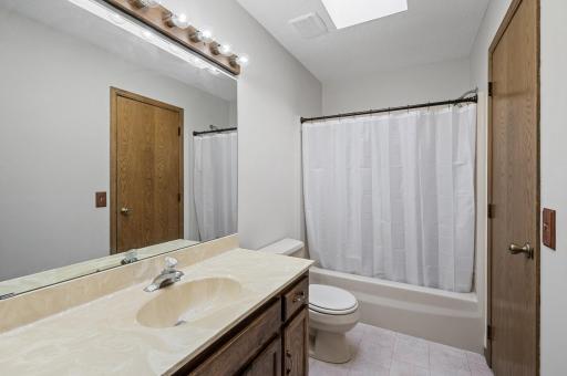 The full bathroom on the upper level offers a fresh coat of neutral gray paint, a oversized refinished wood vanity, and a convenient bathtub/shower combo.