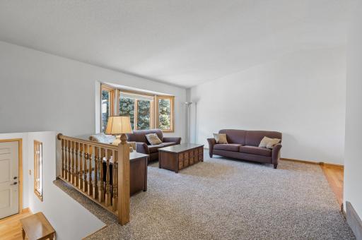 The upper level living room is light and bright with a vaulted ceiling, new carpet, and fresh paint.