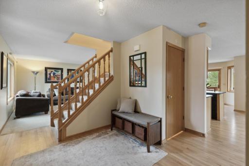 Spacious foyer with hardwood floors, updated lighting and a closet.