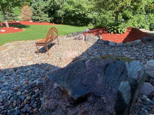 A landscape feature with the flip of a switch: soothing water flowing over this boulder close to the beautiful & welcoming front entrance