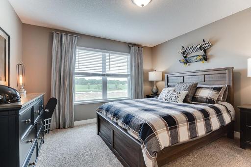 The additional upper level bedrooms are spacious and have their own walk in closets! Example from model home.