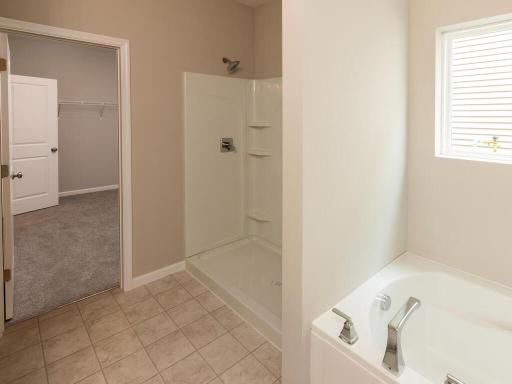 Primary Bathroom. Photo taken of another home with similar plan and finishes. Photos and renderings may not depict actual plan, materials, & finishes may vary. All measurements are approximate.
