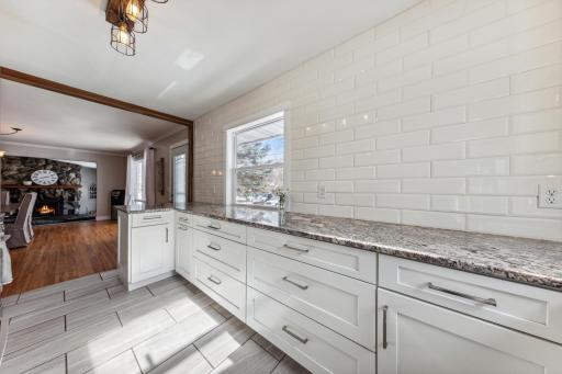 Look at the bright, gleaming subway tiled walls. An abundance of granite countertops for preparing delicious food. Dining Room is adjacent to the Kitchen.