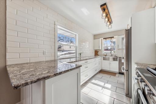 Enjoy this beautiful, remodeled kitchen with new light fixtures, stainless refrigerator, range, microwave, and dishwasher. New stainless sink with garbage disposal, granite countertops, soft close cabinets and drawers, plus new tile flooring.
