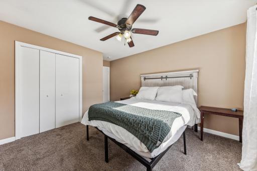 Bedroom 1 has large closet, carpeted floors, and ceiling fan. Wood flooring under carpet