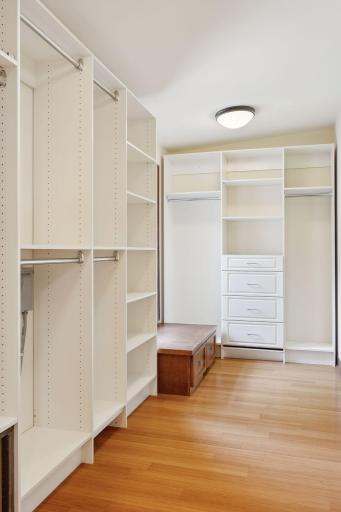 Two walk in primary closets with custom closet organizers.