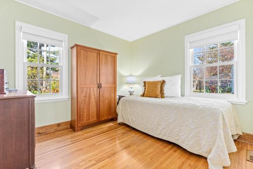1 of 2 main floor bedroom. The windows were replaced in 2017 and new high end blinds were added in 2022. The classic hardwood floors are found throughout the main floor.