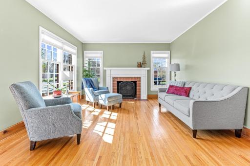 The light drenched living room has south and east facing Andersen windows that were installed in 2017. The original hardwood floors add visual warmth and the classic wood-burning fireplace adds traditional charm.