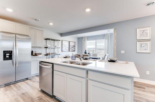 Gorgeous Arctic White cabinets with quartz countertops, beautiful stainless appliances and vented micro-hood to the outside. (Model photo, colors may vary.)