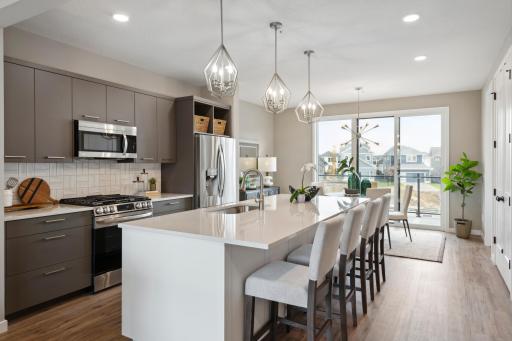Photo of similar model. Spacious large kitchen island with quartz countertops. Open concept floorplan flows right into dining and out to spacious maintenance free deck.