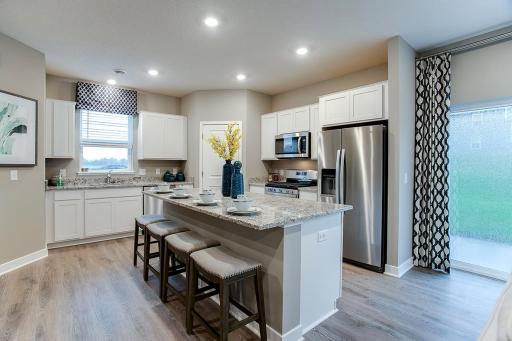 Enjoy having beautiful quartz counters with space for four to sit, and a great kitchen that includes stainless appliances and walk in pantry. Model photos. Options and colors may vary.