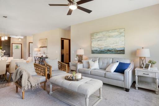 A wonderful open layout carefully designed to create a warm living room space with fireplace, upgraded carpet, ceiling fan, and views to patio.