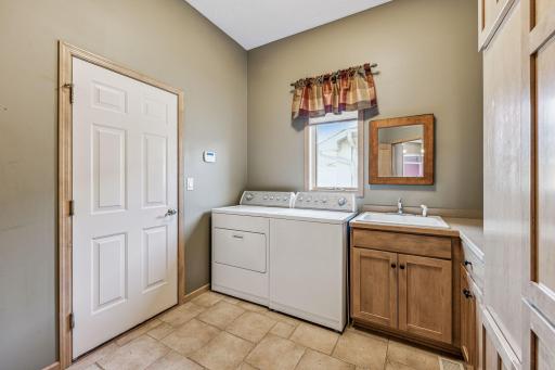 Main floor laundry with maple storage and garage access.