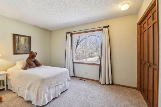 Upper third bedroom with large windows and clothing storage closet with built-in organizer.