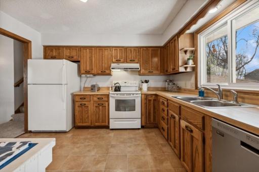 Lovely kitchen opens to the dining room and living room and also features a newer stainless steel dishwasher