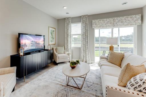 Soaring windows provide an abundance of natural light to flow throughout the main level, including this nicely sized family room. *Pictures are of model, actual colors in home may vary.
