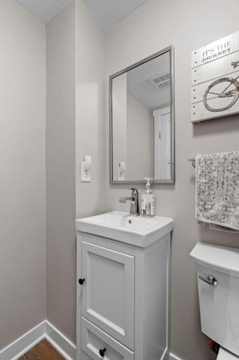 1/2 bath features enameled vanity cabinet off the mudroom