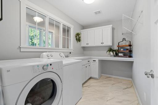 Laundry Room is on the upper level features enameled cabinetry and great countertop space w/ sink. Decorative interior windows transfers natural light